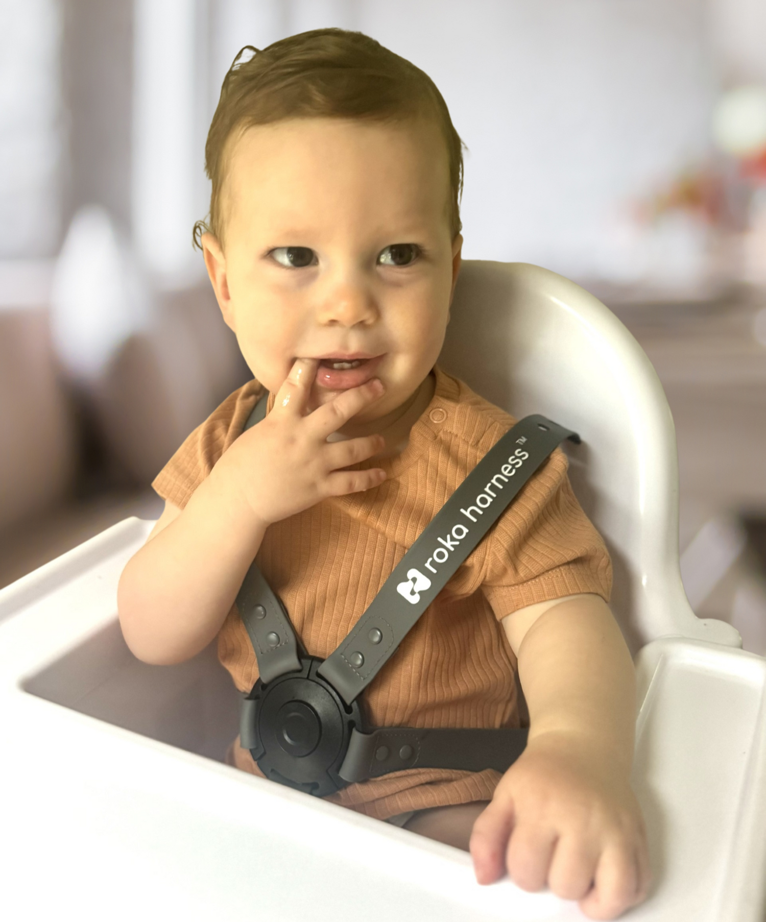 baby in orange shirt wearing roka harness in high chair roka harness rocka rocker